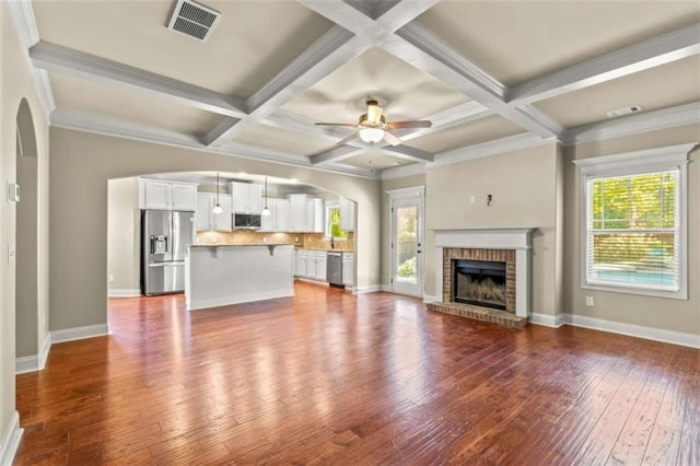 unfurnished living room featuring hardwood / wood-style flooring, coffered ceiling, a fireplace, and visible vents