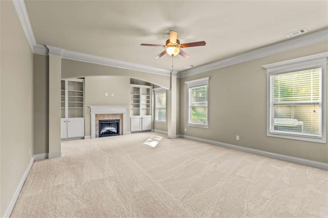 unfurnished living room with baseboards, light colored carpet, visible vents, and crown molding