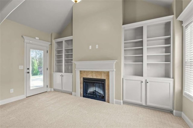 unfurnished living room featuring light carpet, baseboards, vaulted ceiling, and a tile fireplace