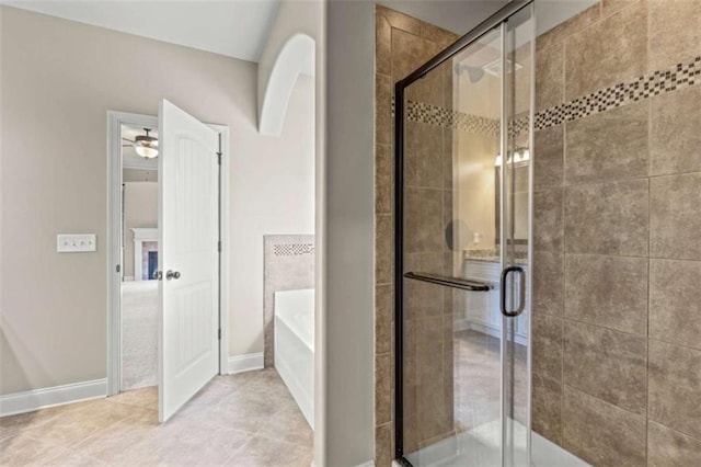 bathroom with a garden tub, a shower stall, baseboards, and tile patterned floors