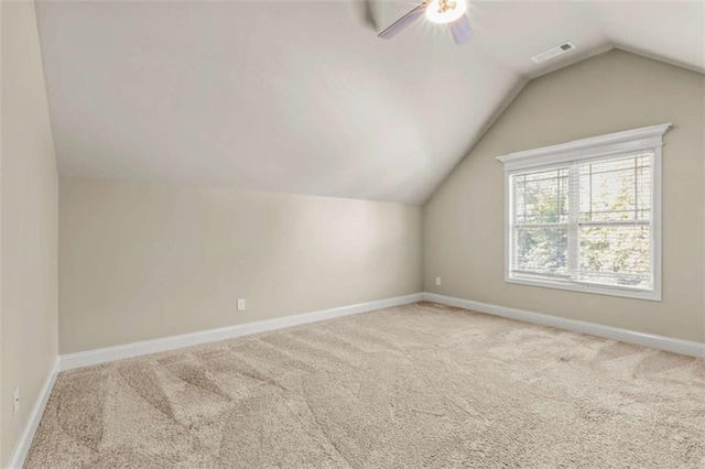 bonus room with light carpet, lofted ceiling, visible vents, and baseboards