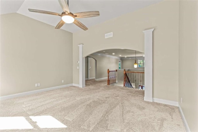 spare room with arched walkways, lofted ceiling, light colored carpet, visible vents, and baseboards