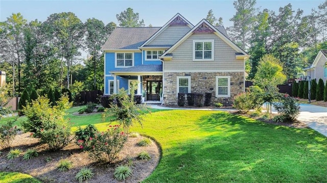 view of front of home with stone siding and a front lawn