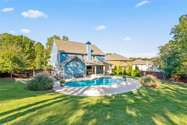 back of house featuring a fenced in pool, a patio, a fenced backyard, a chimney, and a yard