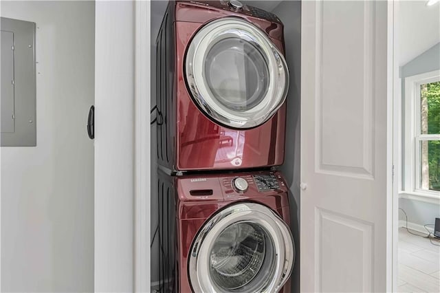 washroom with stacked washer and dryer and electric panel