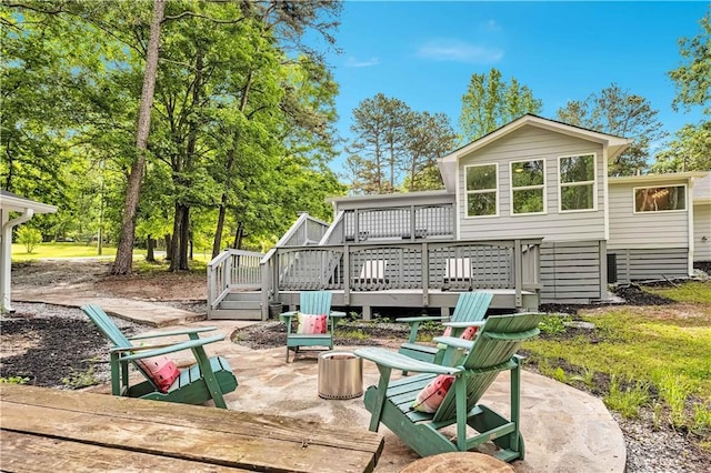 rear view of house featuring a wooden deck and a patio