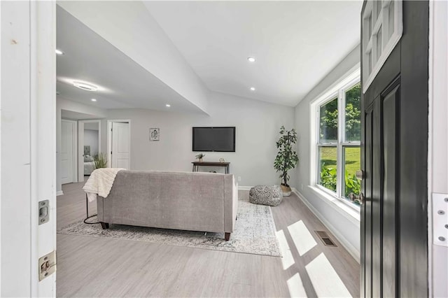 living room featuring vaulted ceiling and light hardwood / wood-style floors