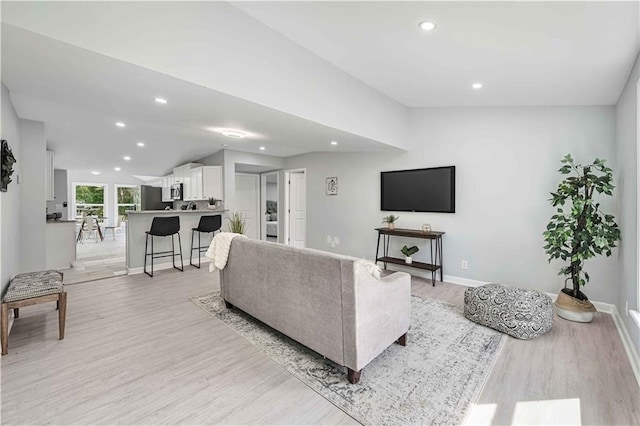 living room with lofted ceiling and light hardwood / wood-style floors