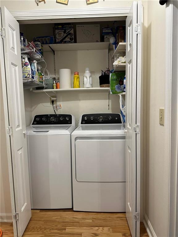 laundry room featuring hardwood / wood-style flooring and washer and dryer