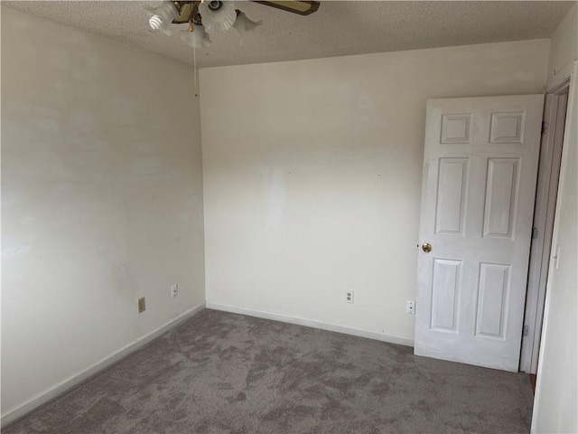 spare room with ceiling fan, dark carpet, and a textured ceiling