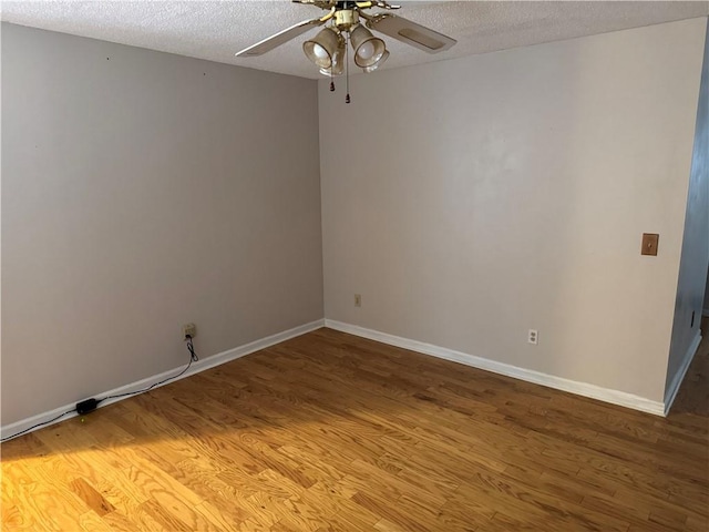 empty room with ceiling fan, hardwood / wood-style flooring, and a textured ceiling