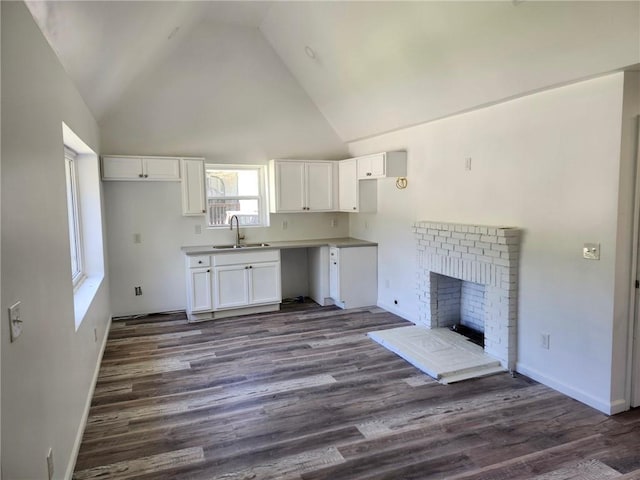 2040 Chicago Ave NW, Atlanta, GA 30314 - kitchen with a sink, white cabinetry, dark wood-style floors, baseboards, and high vaulted ceiling