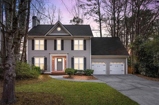 view of front of home with a garage and a yard