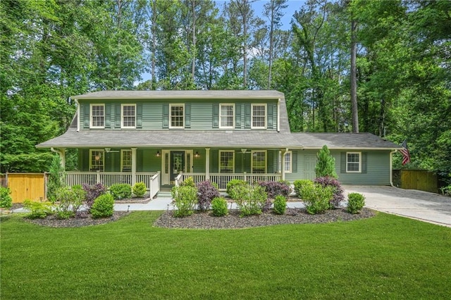 view of front of house with a front yard, driveway, covered porch, and fence