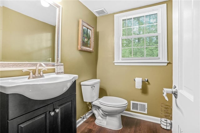 half bath with toilet, baseboards, and visible vents