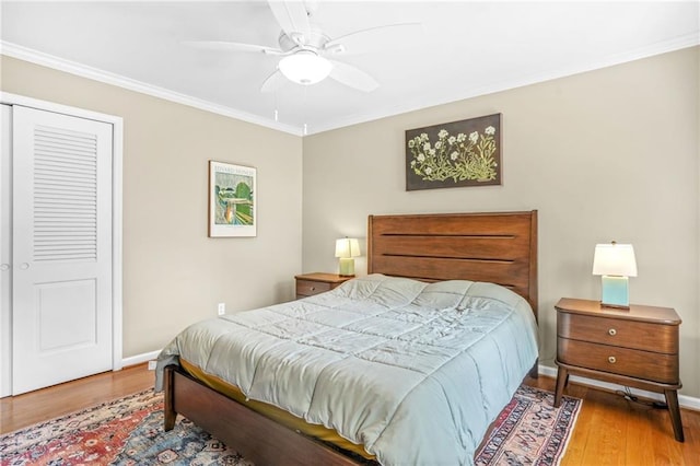 bedroom featuring crown molding, baseboards, a ceiling fan, and wood finished floors