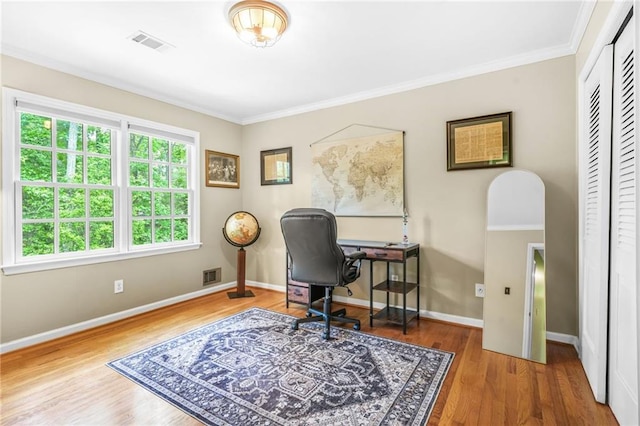 office featuring baseboards, crown molding, visible vents, and wood finished floors
