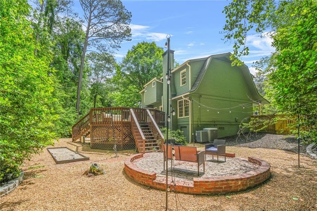 view of playground with fence, cooling unit, stairs, a patio area, and a deck