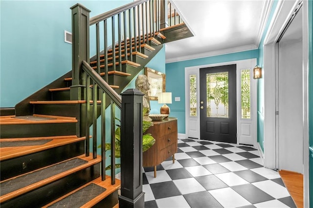 foyer entrance with tile patterned floors, visible vents, ornamental molding, and stairs