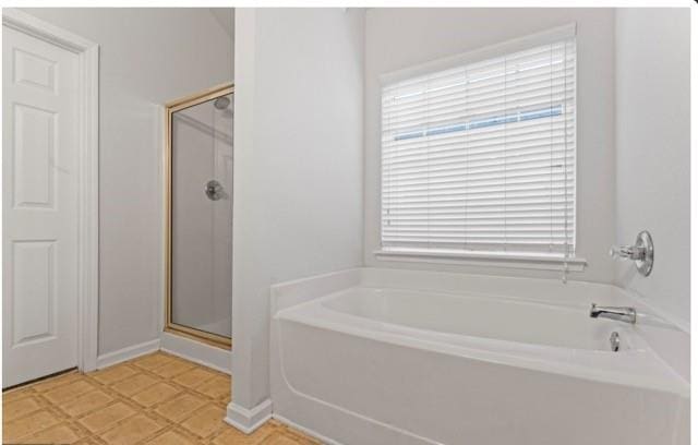 full bath with tile patterned floors, a shower stall, and a bath