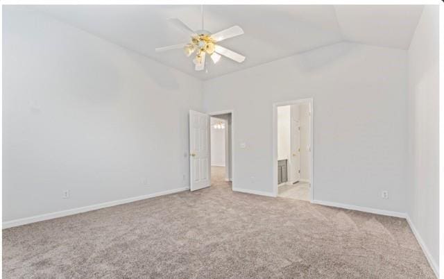 unfurnished bedroom featuring lofted ceiling, light carpet, baseboards, and ensuite bathroom