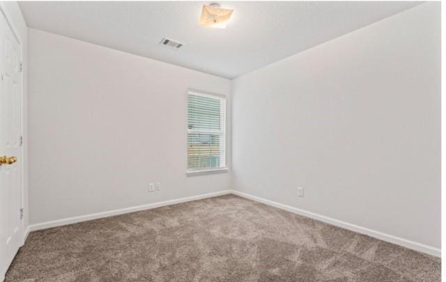 carpeted empty room featuring baseboards and visible vents