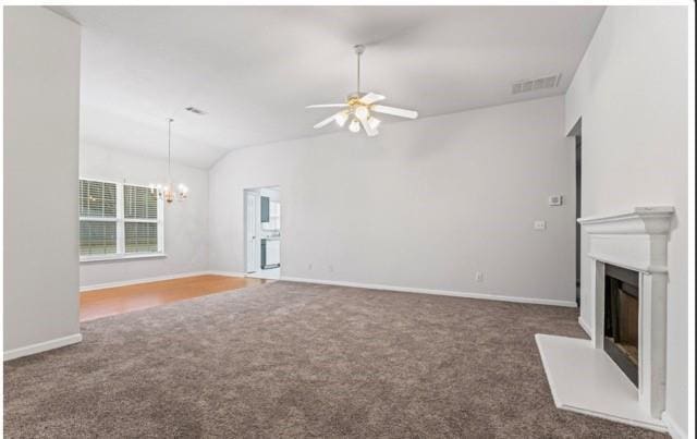 unfurnished living room with visible vents, a glass covered fireplace, vaulted ceiling, dark carpet, and ceiling fan with notable chandelier