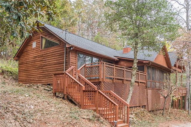 exterior space featuring a wooden deck and a sunroom