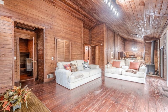 unfurnished living room featuring wood-type flooring, a wood stove, wooden ceiling, and wood walls