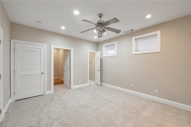 unfurnished bedroom with recessed lighting, baseboards, light colored carpet, and visible vents