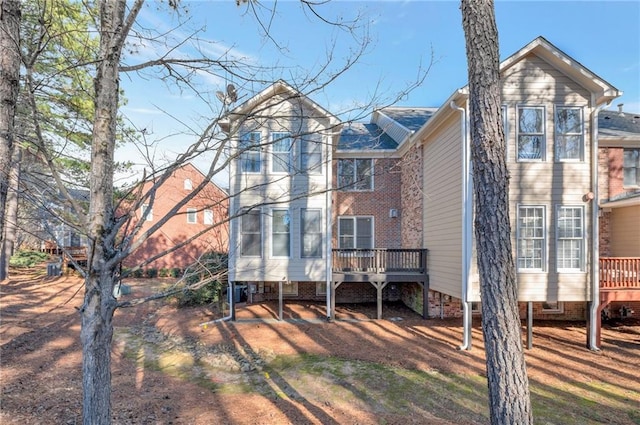 back of property featuring a deck and a sunroom