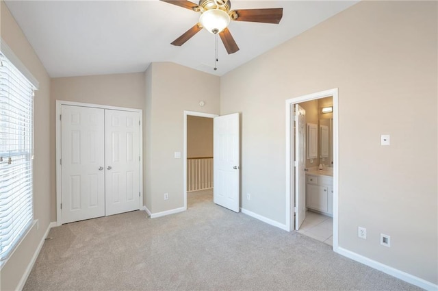 unfurnished bedroom featuring a closet, vaulted ceiling, multiple windows, and light colored carpet