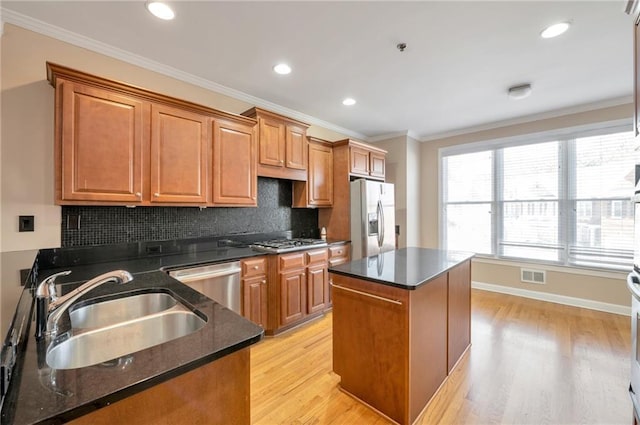 kitchen with a sink, visible vents, ornamental molding, and appliances with stainless steel finishes