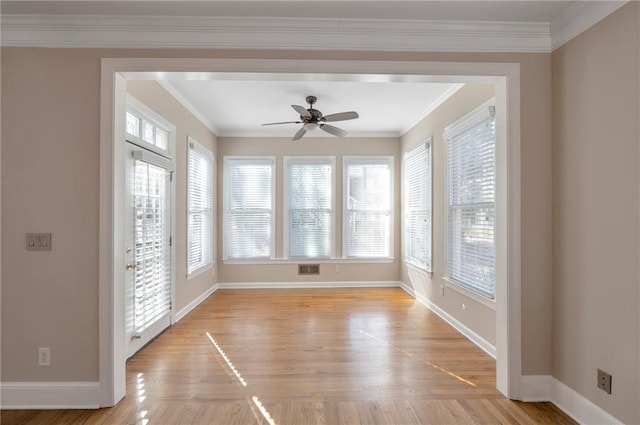 interior space featuring crown molding, baseboards, light wood finished floors, visible vents, and ceiling fan