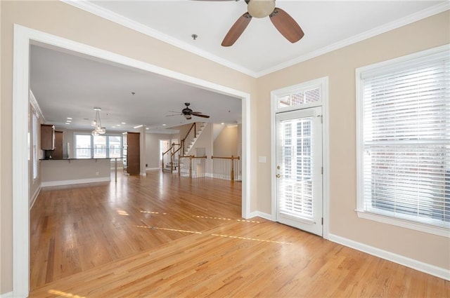 interior space featuring a ceiling fan, crown molding, and light wood-style floors