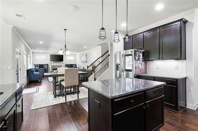 176 Red Wood Dr, Dallas, GA 30132 - kitchen with crown molding, light stone counters, stainless steel fridge, open floor plan, and visible vents