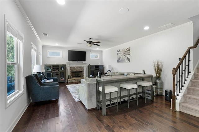 176 Red Wood Dr, Dallas, GA 30132 - living area with crown molding, ceiling fan, a stone fireplace, stairs, and dark wood-style floors
