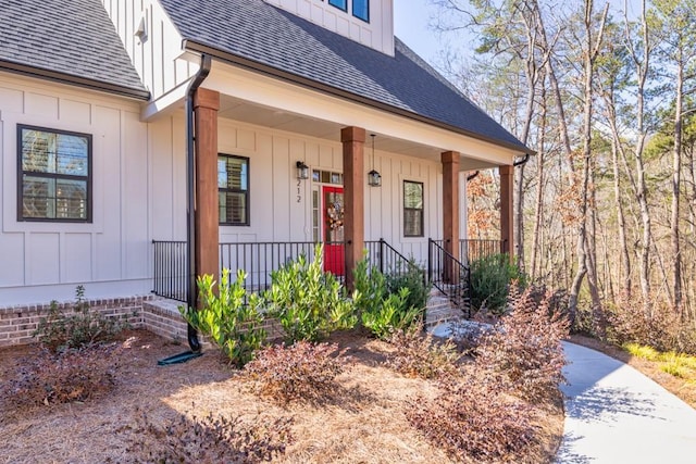 entrance to property featuring covered porch, board and batten siding, and a shingled roof