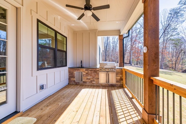 deck with area for grilling, a ceiling fan, and a sink