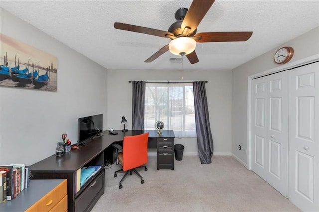 carpeted office space featuring a textured ceiling