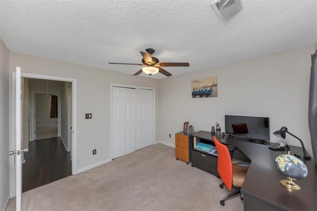 office space featuring ceiling fan, light colored carpet, and a textured ceiling