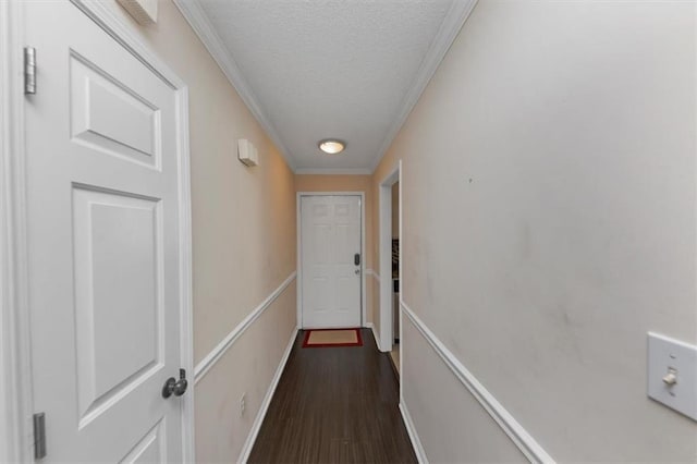 hallway with crown molding, dark wood-type flooring, and a textured ceiling