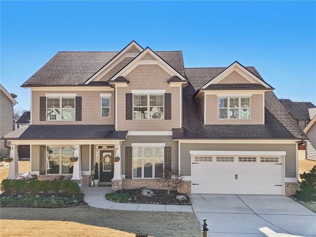 craftsman house with a front yard, a porch, and a garage