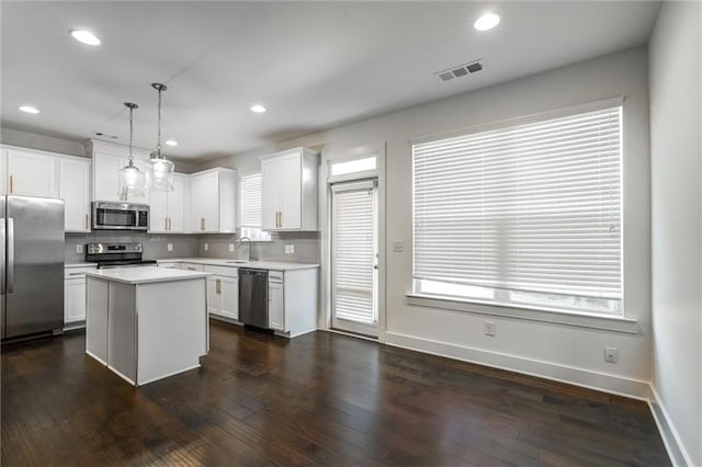 kitchen featuring dark wood finished floors, decorative backsplash, visible vents, and appliances with stainless steel finishes