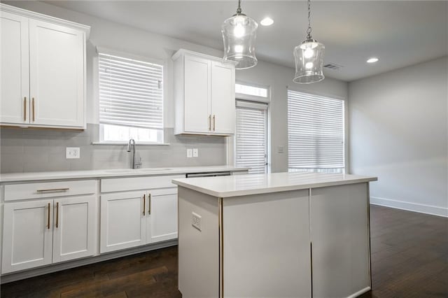 kitchen featuring a sink, visible vents, dark wood-type flooring, and light countertops