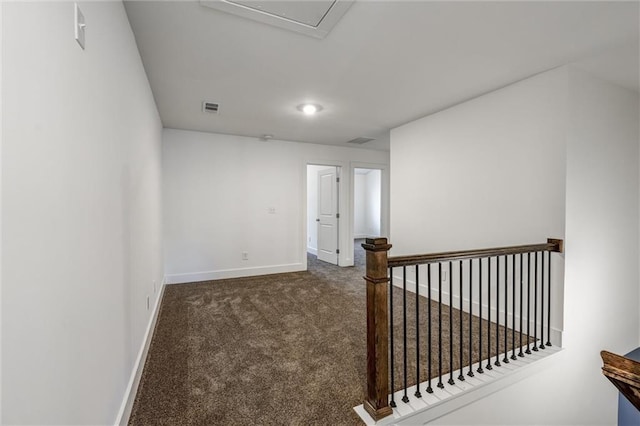 hallway featuring visible vents, an upstairs landing, baseboards, and carpet flooring