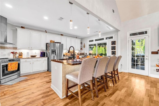 kitchen with pendant lighting, appliances with stainless steel finishes, plenty of natural light, and white cabinetry