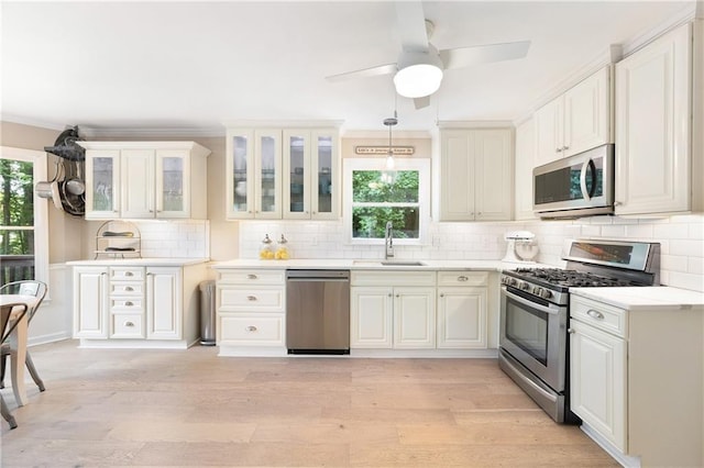4522 Reva Ct NE, Marietta, GA 30066 - kitchen featuring stainless steel appliances, light wood finished floors, glass insert cabinets, light countertops, and backsplash