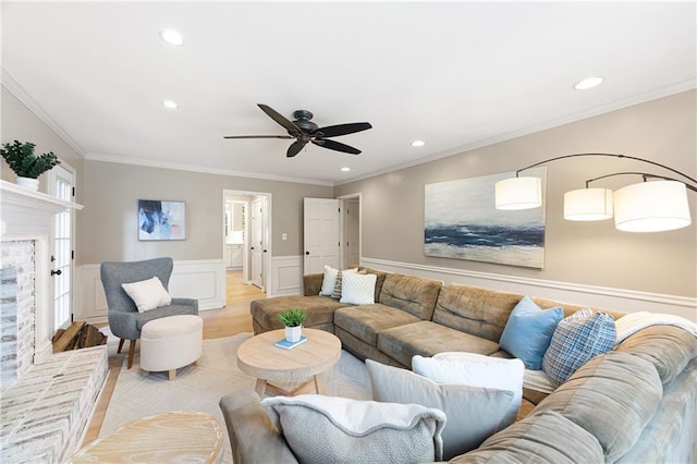 4522 Reva Ct NE, Marietta, GA 30066 - living room with ceiling fan, wainscoting, ornamental molding, light wood-style flooring, and a brick fireplace