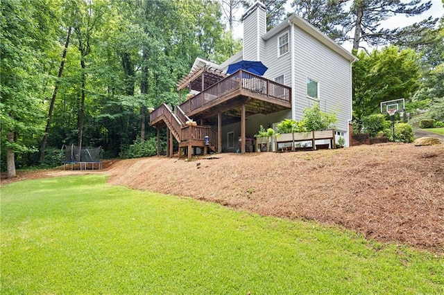 4522 Reva Ct NE, Marietta, GA 30066 - rear view of house with a trampoline, a wooden deck, a lawn, stairway, and a chimney